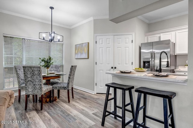 7800 Point Meadows Dr Unit 1511, Jacksonville, FL 32256 - dining area with ornamental molding, a healthy amount of sunlight, an inviting chandelier, and light wood finished floors
