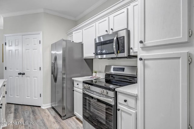 7800 Point Meadows Dr Unit 1511, Jacksonville, FL 32256 - kitchen with appliances with stainless steel finishes, baseboards, white cabinets, light wood-style floors, and ornamental molding