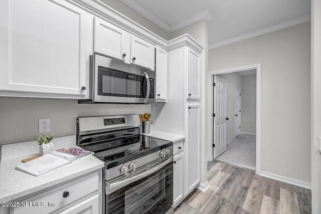 7800 Point Meadows Dr Unit 1511, Jacksonville, FL 32256 - kitchen with crown molding, light wood-style flooring, stainless steel appliances, baseboards, and white cabinets