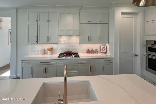 928 Caiden Dr, Ponte Vedra, FL 32081 - kitchen with appliances with stainless steel finishes, light countertops, a sink, backsplash, and baseboards