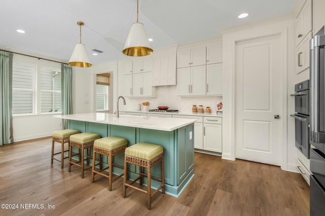 928 Caiden Dr, Ponte Vedra, FL 32081 - kitchen featuring a sink, light countertops, wood finished floors, a kitchen breakfast bar, and a kitchen island with sink