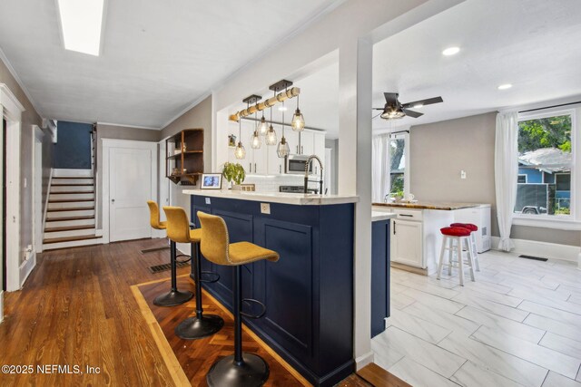 2541 Grand St, Jacksonville, FL 32208 - bar with stairway, hanging light fixtures, decorative backsplash, ceiling fan, and stainless steel microwave
