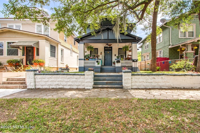 view of front facade featuring ceiling fan, covered porch, and a fenced front yard