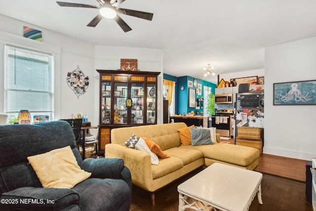 living room featuring ceiling fan with notable chandelier and wood finished floors