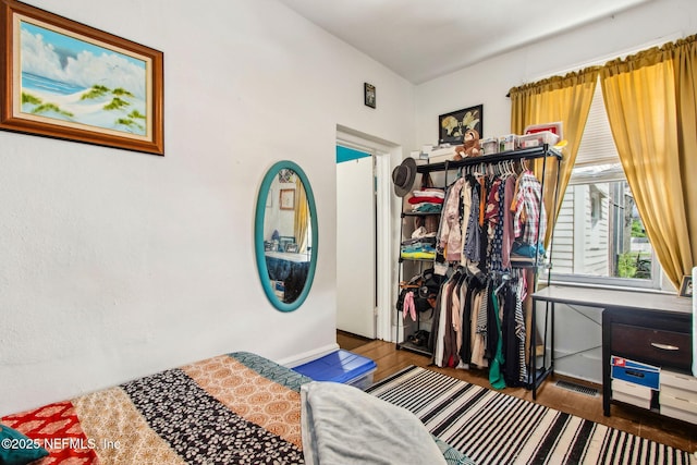 bedroom featuring wood finished floors and visible vents