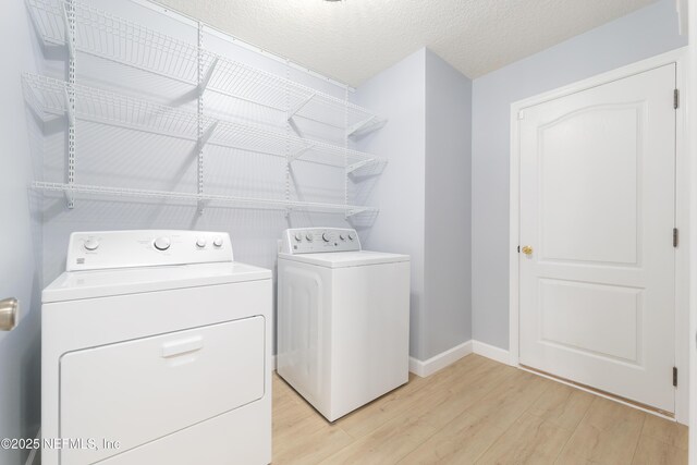 476 Monet Ave, Ponte Vedra, FL 32081 - washroom with independent washer and dryer, baseboards, a textured ceiling, light wood-style floors, and laundry area