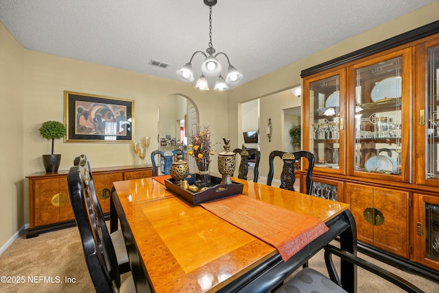 dining space with a notable chandelier, visible vents, and light carpet
