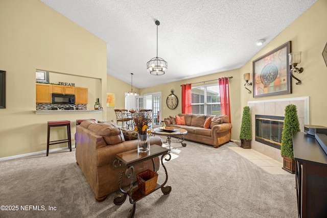 carpeted living room with lofted ceiling, a textured ceiling, baseboards, an inviting chandelier, and a tile fireplace