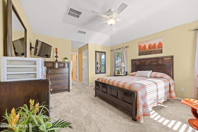 carpeted bedroom with a textured ceiling, visible vents, ceiling fan, and baseboards