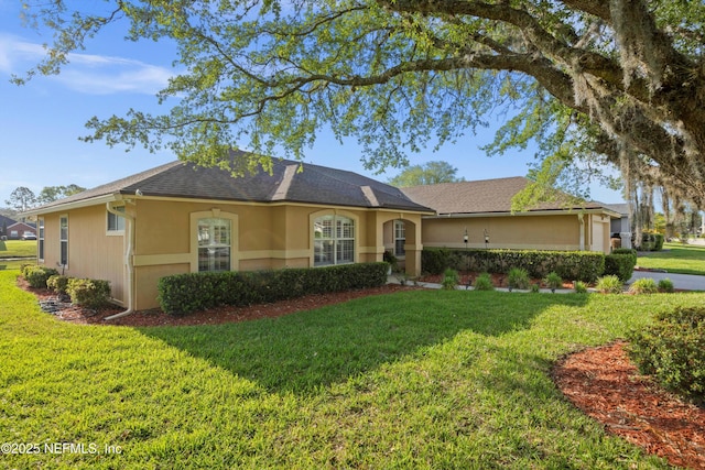 ranch-style home featuring a front yard and stucco siding