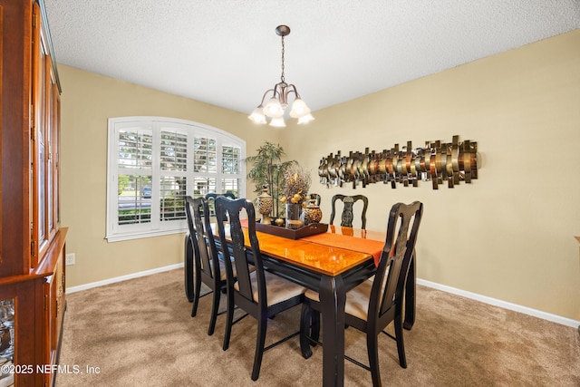 dining room with baseboards, an inviting chandelier, a textured ceiling, and carpet