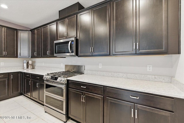 55 Cool Springs Ave, Ponte Vedra, FL 32081 - kitchen featuring light tile patterned flooring, a textured ceiling, light countertops, stainless steel appliances, and dark brown cabinets