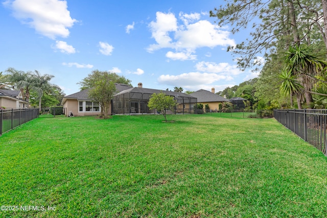 view of yard with a fenced backyard and glass enclosure