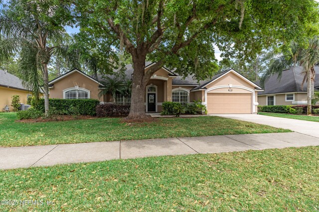ranch-style home with a front yard, driveway, stucco siding, and an attached garage