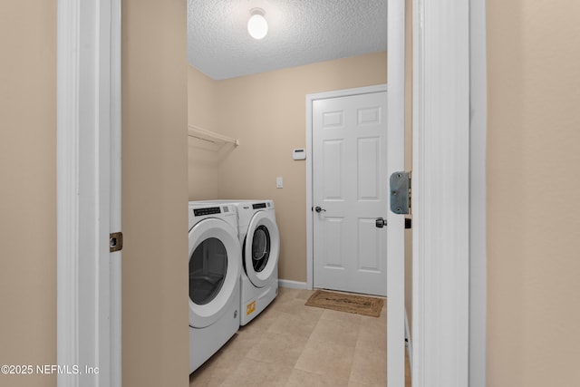 laundry room with independent washer and dryer, laundry area, and a textured ceiling