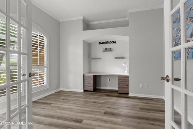interior space with french doors, baseboards, crown molding, and wood finished floors
