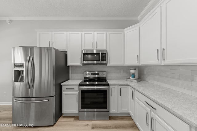 kitchen with crown molding, appliances with stainless steel finishes, light wood finished floors, and white cabinets