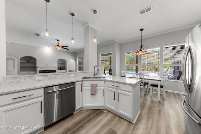 kitchen with ceiling fan, a textured ceiling, visible vents, a sink, and stainless steel appliances