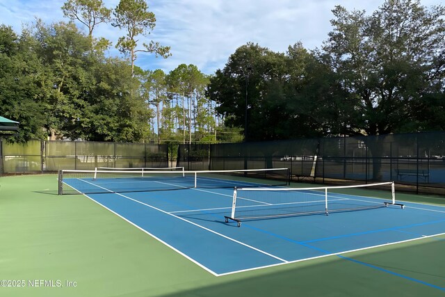 view of tennis court featuring community basketball court and fence