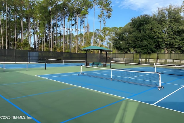 view of tennis court with community basketball court and fence