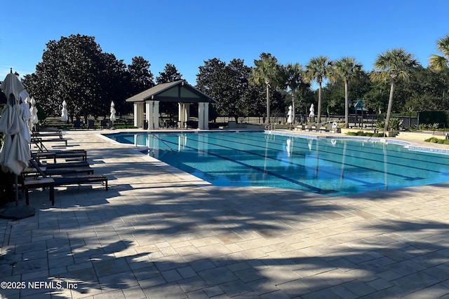 community pool featuring a patio area, a gazebo, and fence
