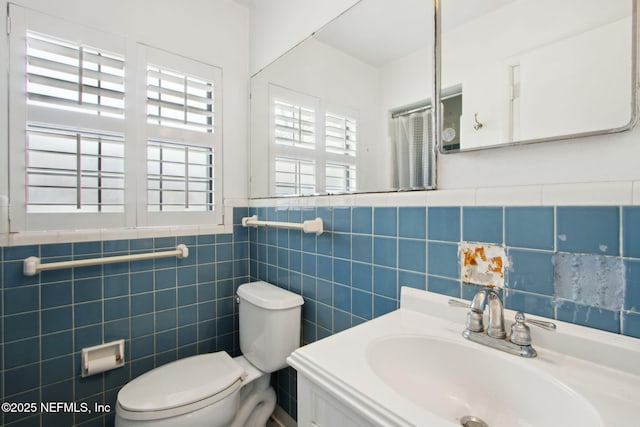 709 Amelia Dr, Fernandina Beach, FL 32034 - bathroom with toilet, a sink, tile walls, and wainscoting