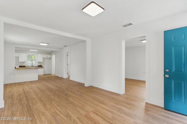 1539 7th St W, Jacksonville, FL 32209 - unfurnished living room featuring baseboards, visible vents, and light wood-style flooring