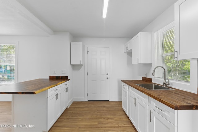 1539 7th St W, Jacksonville, FL 32209 - kitchen with a healthy amount of sunlight, a sink, light wood-style floors, butcher block counters, and a peninsula