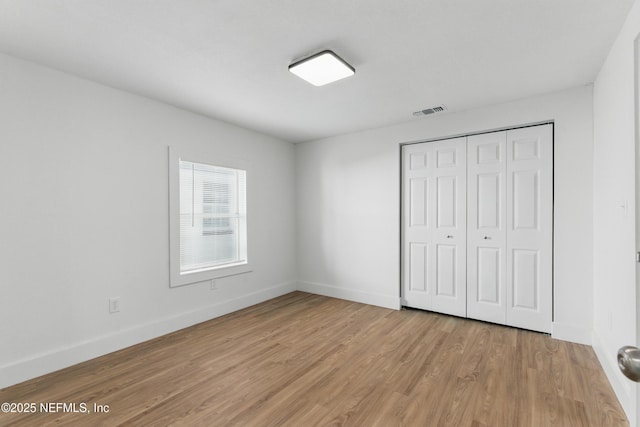 1539 7th St W, Jacksonville, FL 32209 - unfurnished bedroom featuring light wood-style flooring, a closet, baseboards, and visible vents