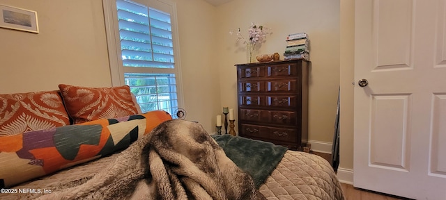 sitting room with baseboards and wood finished floors