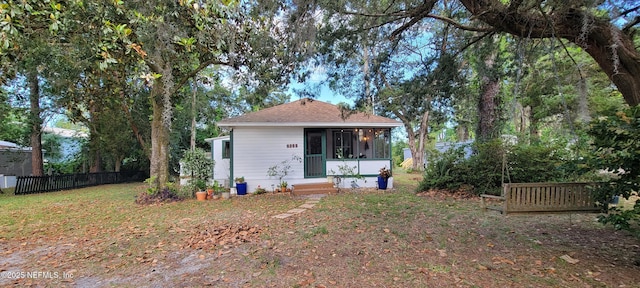 rear view of property with fence and a sunroom