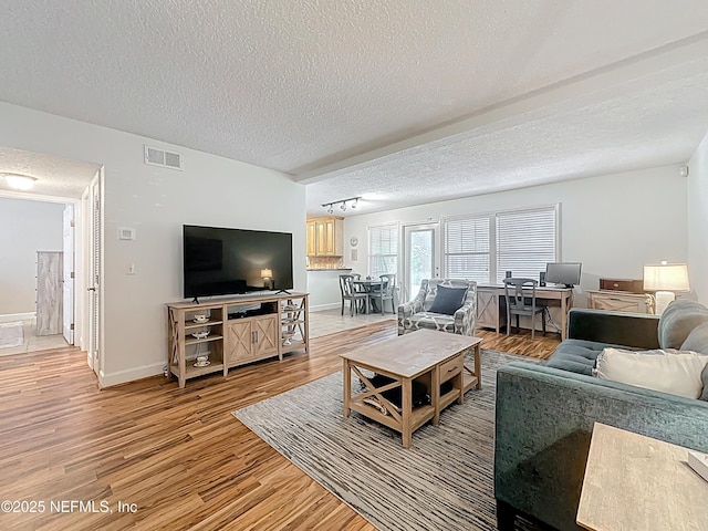 3434 Blanding Blvd Unit 116, Jacksonville, FL 32210 - living room with visible vents, track lighting, light wood-type flooring, and a textured ceiling