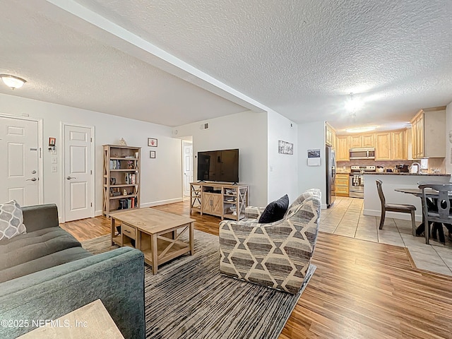 3434 Blanding Blvd Unit 116, Jacksonville, FL 32210 - living room with baseboards, visible vents, light wood-style flooring, and a textured ceiling