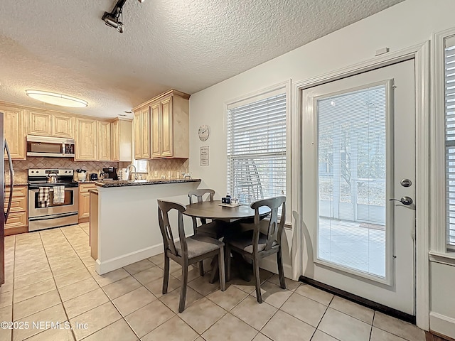 3434 Blanding Blvd Unit 116, Jacksonville, FL 32210 - kitchen featuring decorative backsplash, a peninsula, appliances with stainless steel finishes, light brown cabinets, and light tile patterned floors