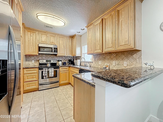 3434 Blanding Blvd Unit 116, Jacksonville, FL 32210 - kitchen with visible vents, a peninsula, appliances with stainless steel finishes, a sink, and light tile patterned floors