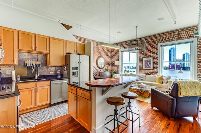 301 E Bay St Unit 405, Jacksonville, FL 32202 - kitchen featuring a kitchen breakfast bar, open floor plan, dark countertops, appliances with stainless steel finishes, and a sink