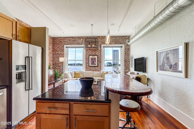 301 E Bay St Unit 405, Jacksonville, FL 32202 - kitchen with a textured ceiling, high quality fridge, a breakfast bar, a textured wall, and dark wood-style floors