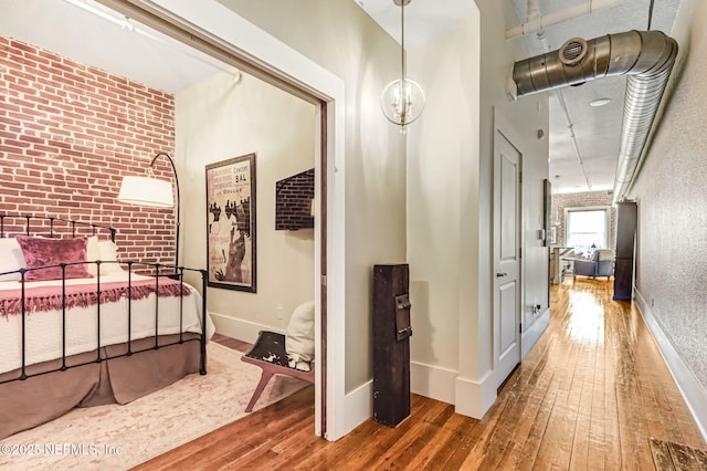 301 E Bay St Unit 405, Jacksonville, FL 32202 - hallway featuring wood-type flooring, baseboards, an accent wall, and brick wall