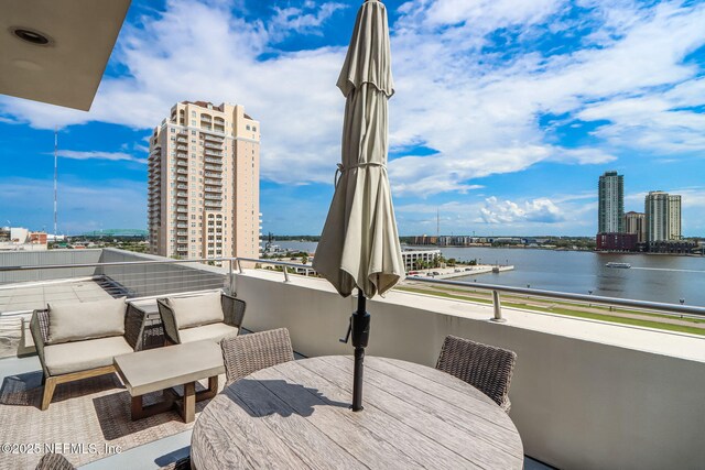 301 E Bay St Unit 405, Jacksonville, FL 32202 - view of patio with a city view, outdoor dining space, a balcony, and a water view
