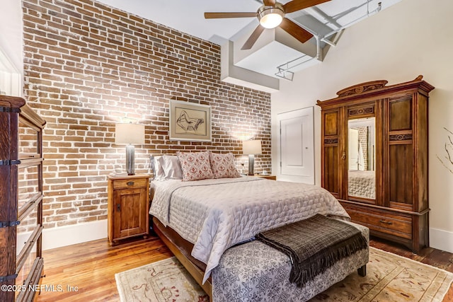 301 E Bay St Unit 405, Jacksonville, FL 32202 - bedroom featuring brick wall, ceiling fan, light wood-style floors, and baseboards