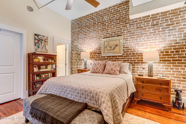 301 E Bay St Unit 405, Jacksonville, FL 32202 - bedroom with ceiling fan, an accent wall, visible vents, wood finished floors, and brick wall