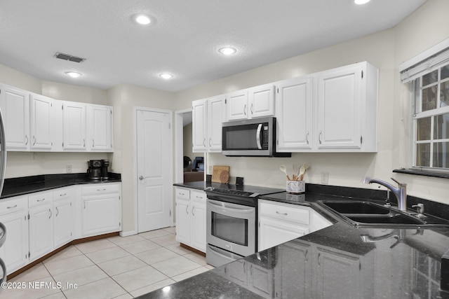 13233 Pecky Cypress Dr, Jacksonville, FL 32223 - kitchen with white cabinets, visible vents, light tile patterned floors, a sink, and appliances with stainless steel finishes