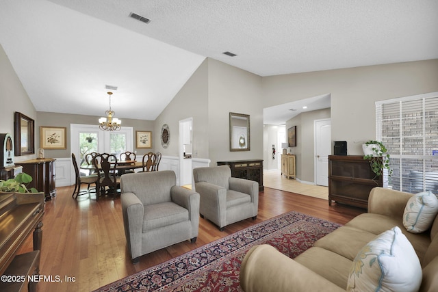 13233 Pecky Cypress Dr, Jacksonville, FL 32223 - living area featuring lofted ceiling, wood finished floors, visible vents, and a chandelier