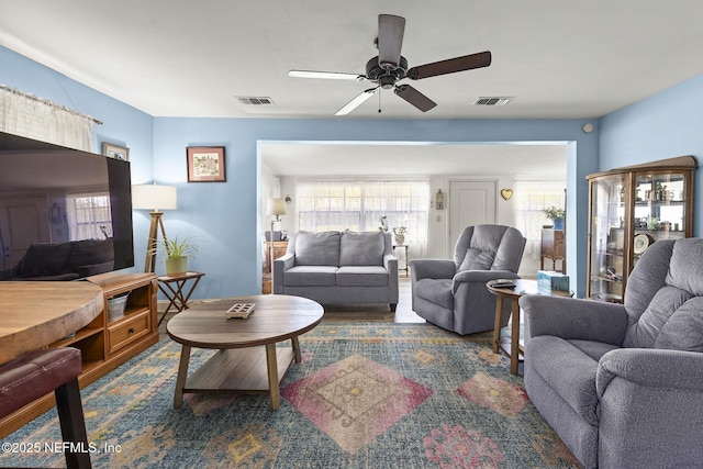living room with visible vents, ceiling fan, and wood finished floors