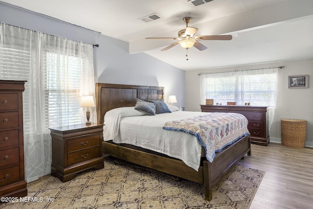 bedroom featuring visible vents, ceiling fan, light wood-type flooring, and lofted ceiling