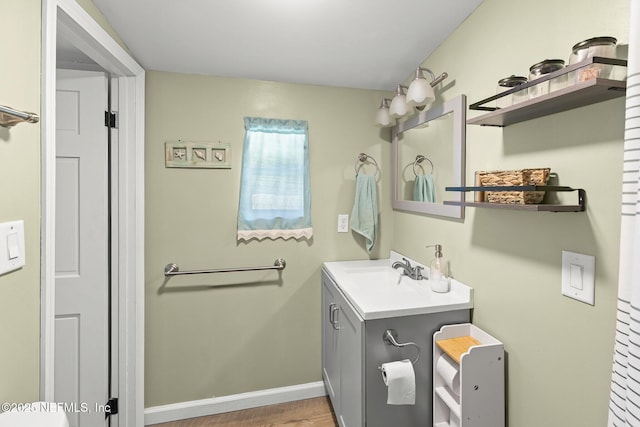 bathroom featuring vanity, baseboards, and wood finished floors