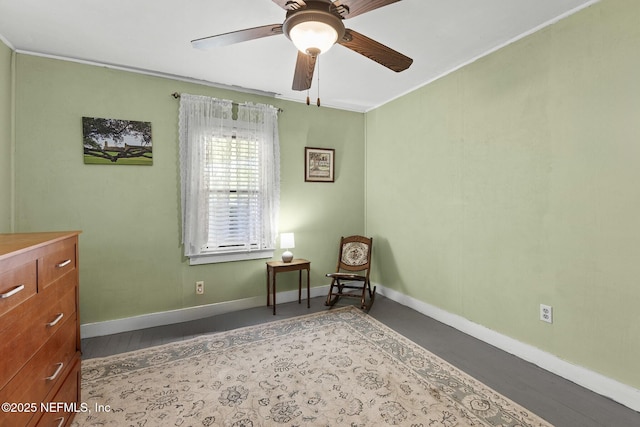 living area featuring baseboards and a ceiling fan