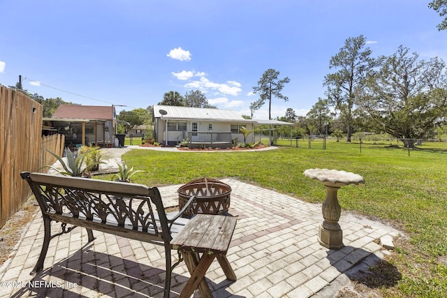 view of patio with fence and a fire pit