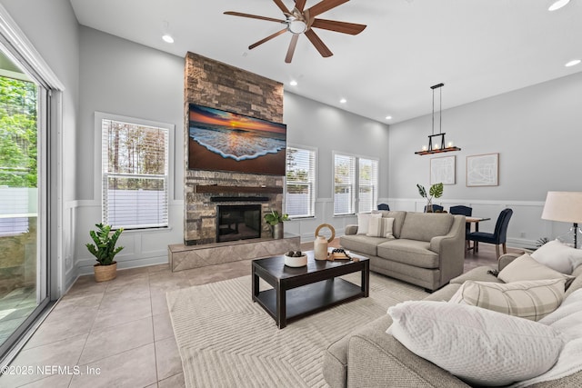 185 Calumet Dr, Saint Johns, FL 32259 - living area with a wainscoted wall, a stone fireplace, tile patterned flooring, ceiling fan with notable chandelier, and recessed lighting