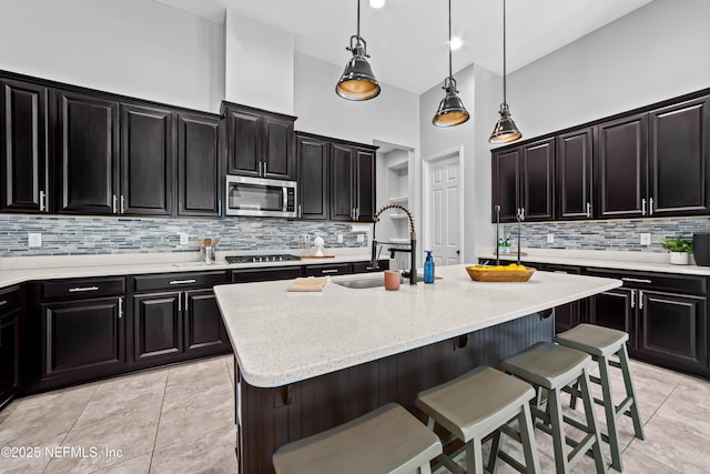 185 Calumet Dr, Saint Johns, FL 32259 - kitchen with a sink, light stone countertops, a breakfast bar, a center island with sink, and stainless steel microwave